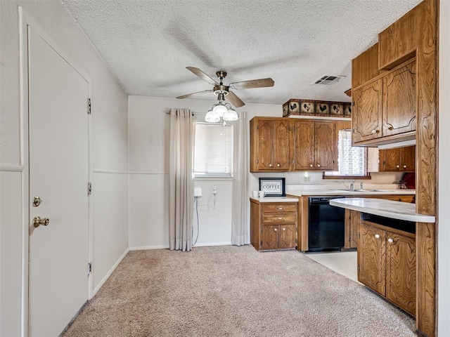 kitchen with black dishwasher, brown cabinets, light colored carpet, light countertops, and a ceiling fan