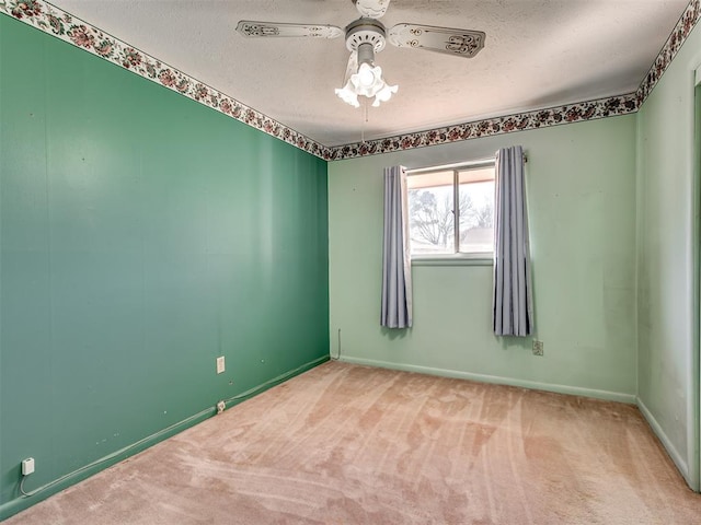 unfurnished room with a textured ceiling, ceiling fan, and carpet