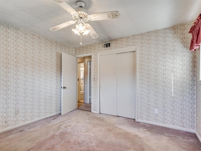 unfurnished bedroom with wallpapered walls, baseboards, visible vents, and carpet flooring