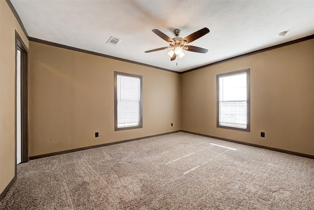 empty room featuring light colored carpet, visible vents, crown molding, and baseboards