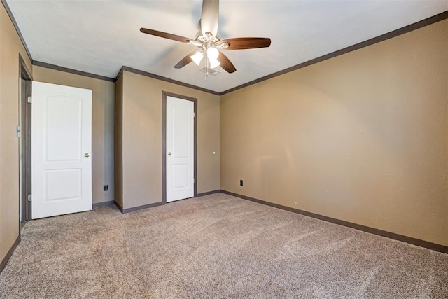 unfurnished bedroom with light carpet, ceiling fan, baseboards, and crown molding