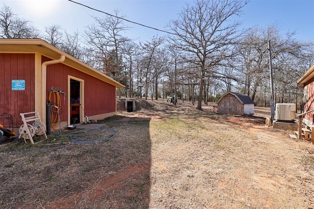 view of yard with a shed, central AC, and an outbuilding