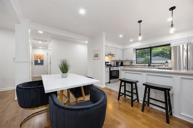 interior space featuring light hardwood / wood-style floors, sink, and ornamental molding