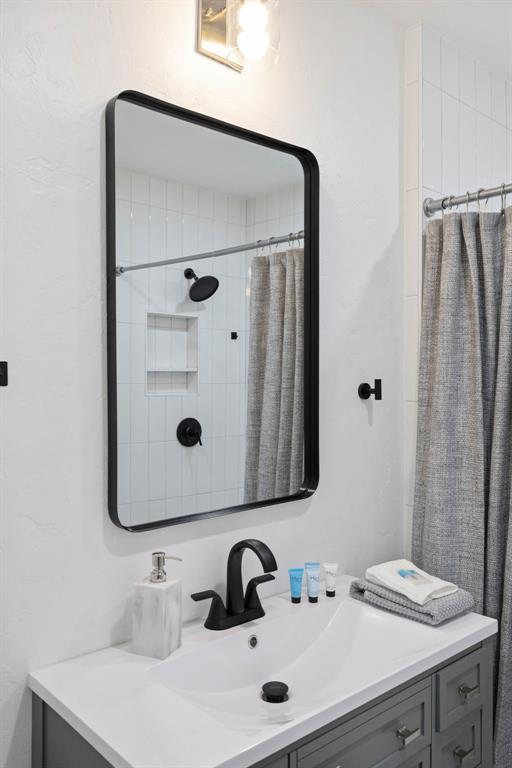 bathroom with a shower with curtain and vanity