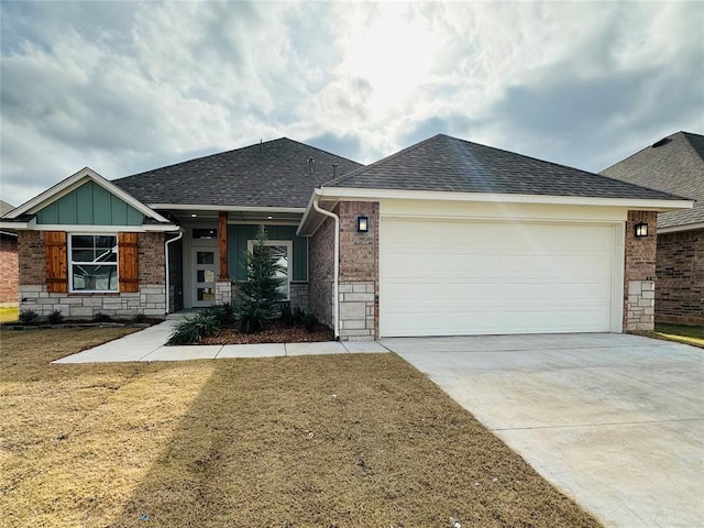 ranch-style house featuring driveway, roof with shingles, a front lawn, stone siding, and a garage