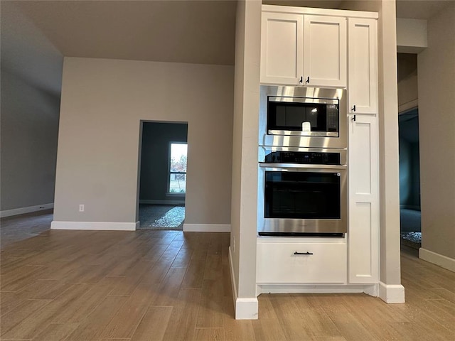 kitchen with white cabinets, light hardwood / wood-style flooring, and appliances with stainless steel finishes