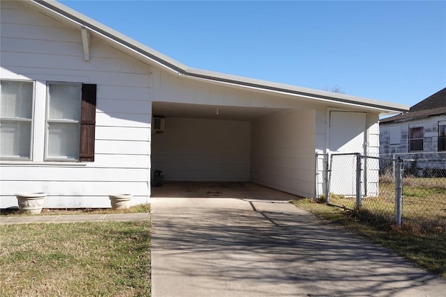 view of home's exterior featuring an attached carport, driveway, and fence