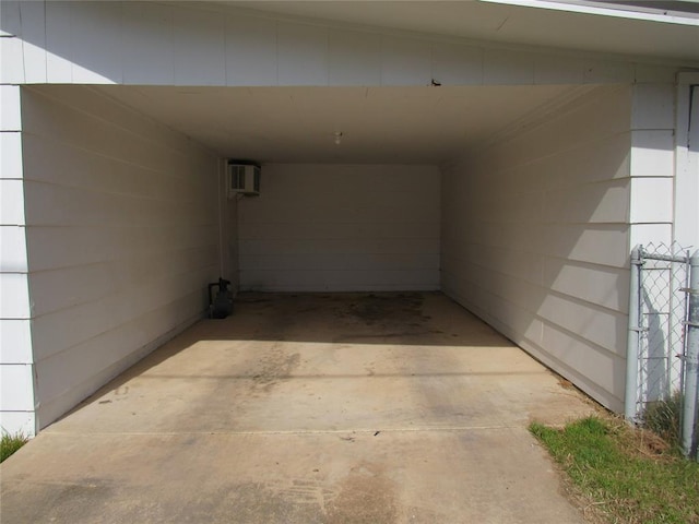 view of parking / parking lot with a carport, driveway, and a wall mounted AC