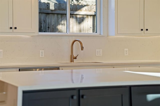 kitchen featuring white cabinetry, sink, and backsplash