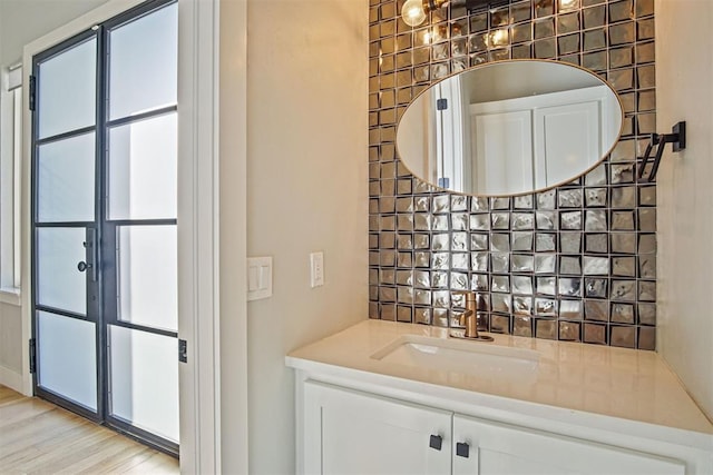 bar with sink, white cabinets, and light hardwood / wood-style floors