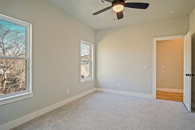 spare room featuring ceiling fan and light carpet