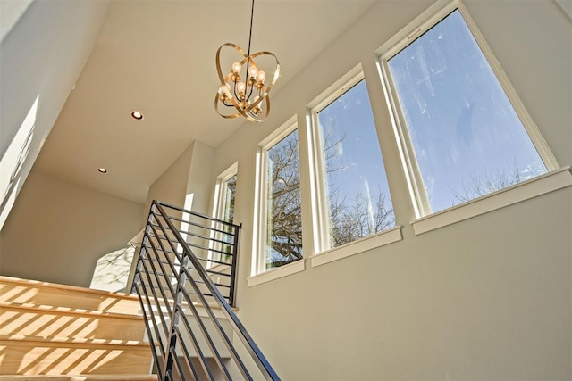 stairs featuring a notable chandelier