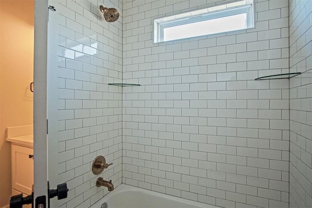 bathroom with tiled shower / bath and vanity