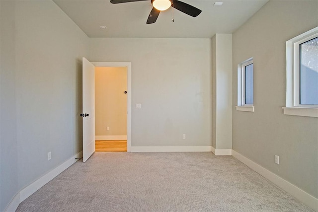 empty room with light colored carpet and ceiling fan