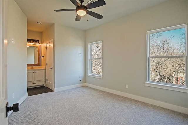 unfurnished bedroom with sink, ensuite bath, ceiling fan, and carpet flooring