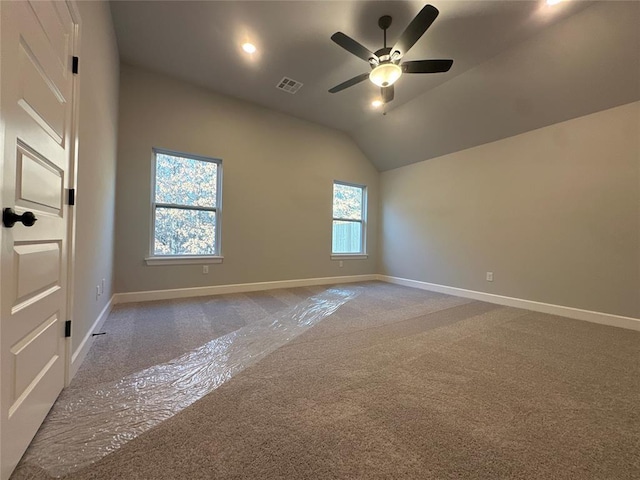 carpeted spare room featuring lofted ceiling and ceiling fan