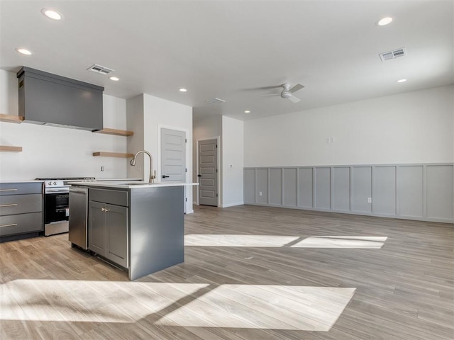 kitchen featuring visible vents, stainless steel stove, gray cabinetry, premium range hood, and open shelves