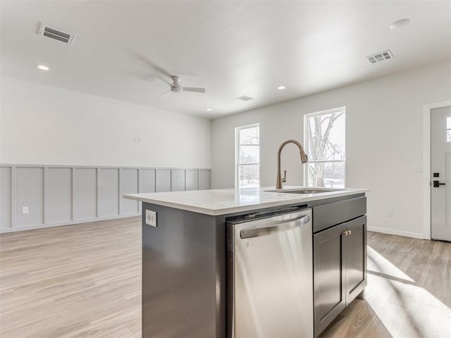 kitchen with visible vents, a sink, an island with sink, and stainless steel dishwasher