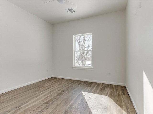 empty room with ceiling fan, baseboards, visible vents, and light wood-style floors