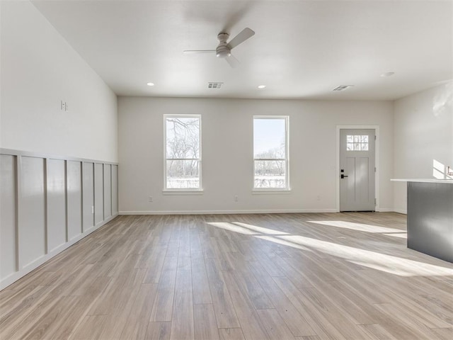 unfurnished living room with baseboards, visible vents, and light wood-style floors