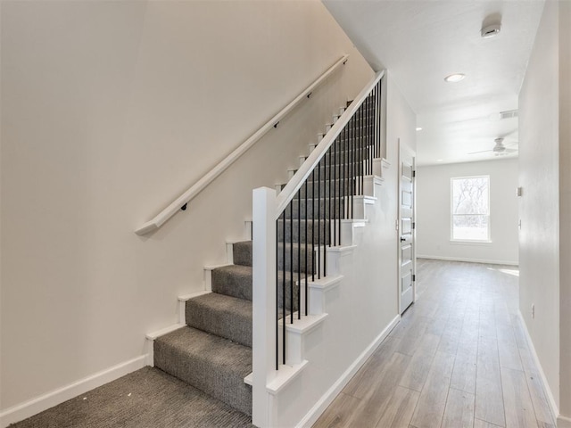 stairs featuring ceiling fan, wood finished floors, visible vents, and baseboards