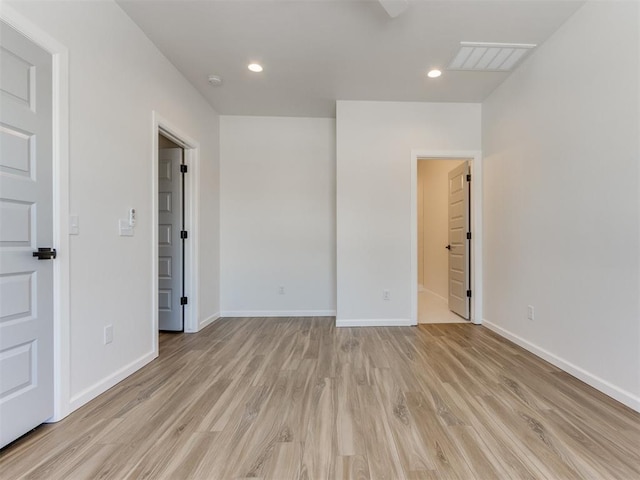 unfurnished room with light wood-type flooring, visible vents, baseboards, and recessed lighting
