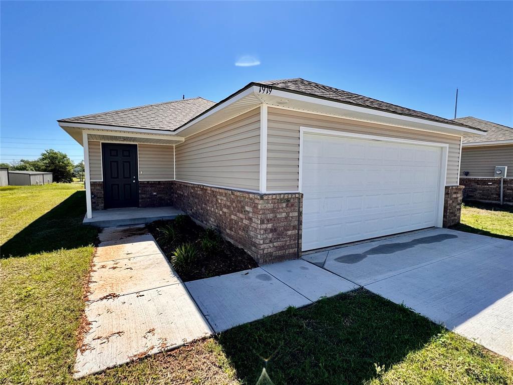 ranch-style home with a front yard and a garage