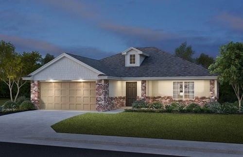 view of front of property with a garage and a lawn