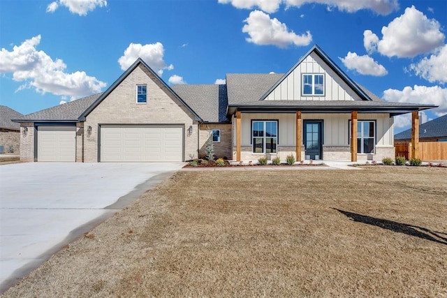 view of front of house featuring a porch, an attached garage, brick siding, concrete driveway, and board and batten siding