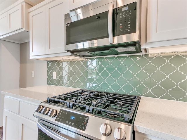 kitchen featuring white cabinets, stainless steel appliances, and tasteful backsplash