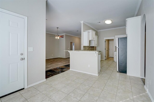 8016 Heather Glen Dr, Yukon, OK 73099 - kitchen with white cabinets, a breakfast bar, light stone counters, and ornamental molding
