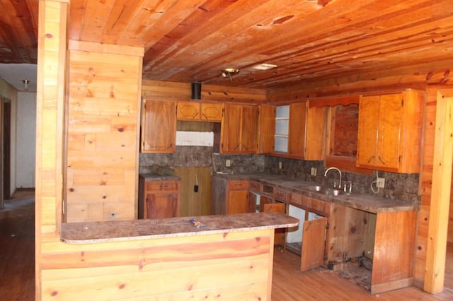 kitchen with sink, wood ceiling, tasteful backsplash, light wood-type flooring, and kitchen peninsula