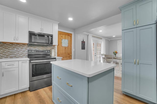 kitchen featuring white cabinetry, appliances with stainless steel finishes, a center island, and light hardwood / wood-style flooring