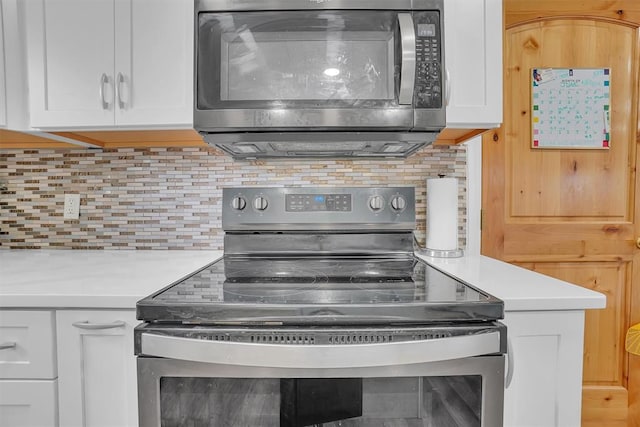 kitchen with appliances with stainless steel finishes, tasteful backsplash, and white cabinetry