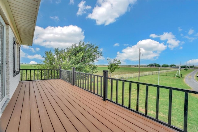 wooden terrace with a rural view and a lawn