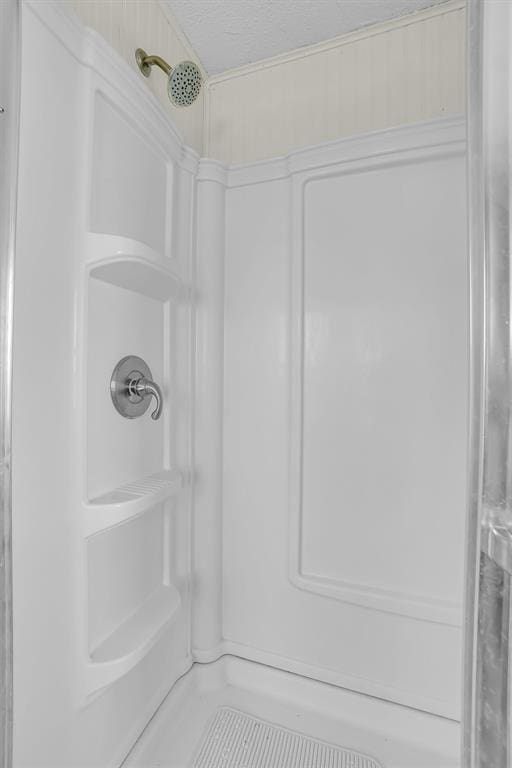 bathroom with a textured ceiling and walk in shower