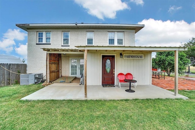 rear view of property with french doors, central AC unit, a patio, and a yard