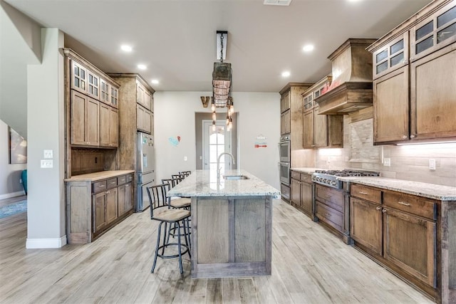 3910 Sienna Rdg, Newcastle, OK 73065 - kitchen with backsplash, a sink, appliances with stainless steel finishes, a center island with sink, and custom exhaust hood