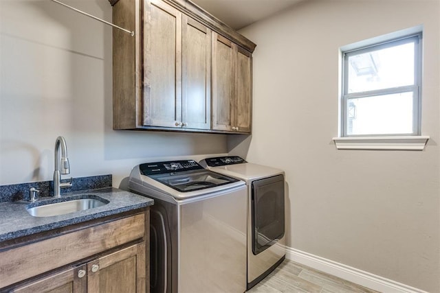 3910 Sienna Rdg, Newcastle, OK 73065 - clothes washing area with washing machine and clothes dryer, light wood finished floors, baseboards, a sink, and cabinet space