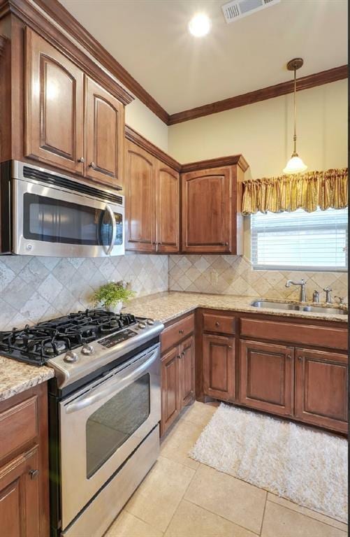 kitchen featuring appliances with stainless steel finishes, light stone countertops, decorative backsplash, crown molding, and sink