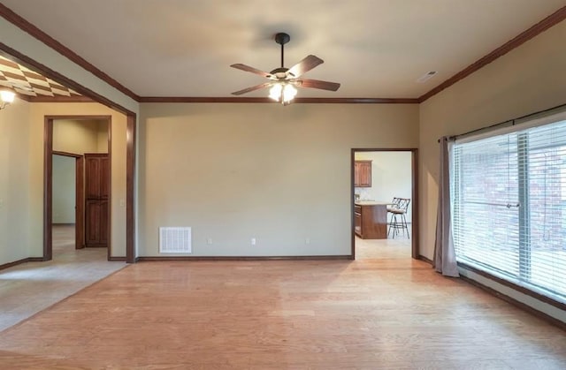 spare room with crown molding, ceiling fan, and light hardwood / wood-style flooring