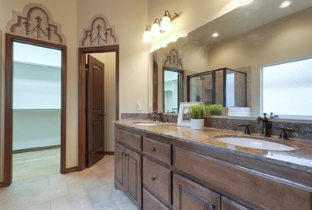 bathroom with tile patterned flooring, plenty of natural light, an enclosed shower, and vanity