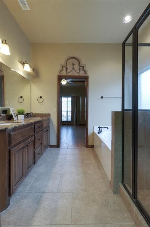 bathroom with vanity and independent shower and bath