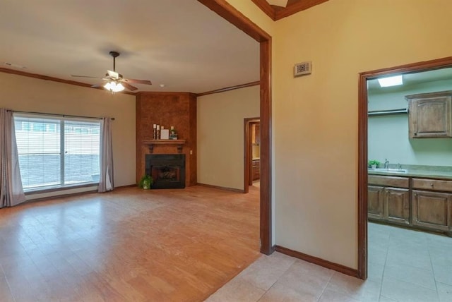 unfurnished living room with ceiling fan, ornamental molding, sink, and light hardwood / wood-style floors