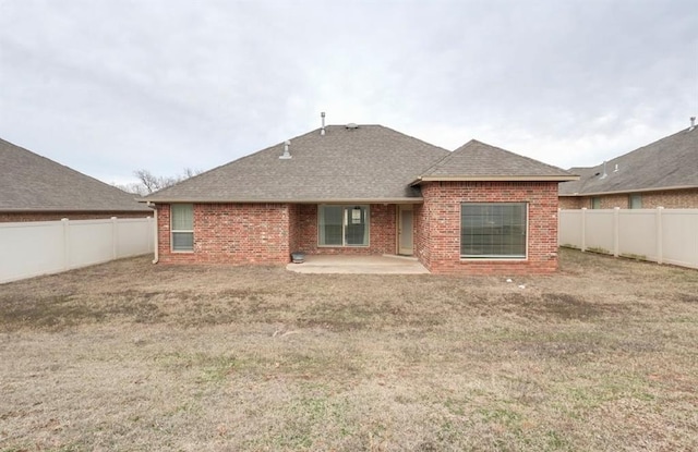 rear view of house with a yard and a patio area