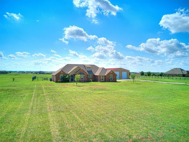 ranch-style house with a rural view, a garage, and a front yard