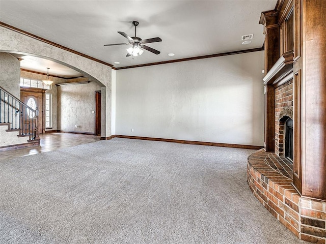 unfurnished living room featuring ceiling fan, ornamental molding, carpet flooring, and a brick fireplace