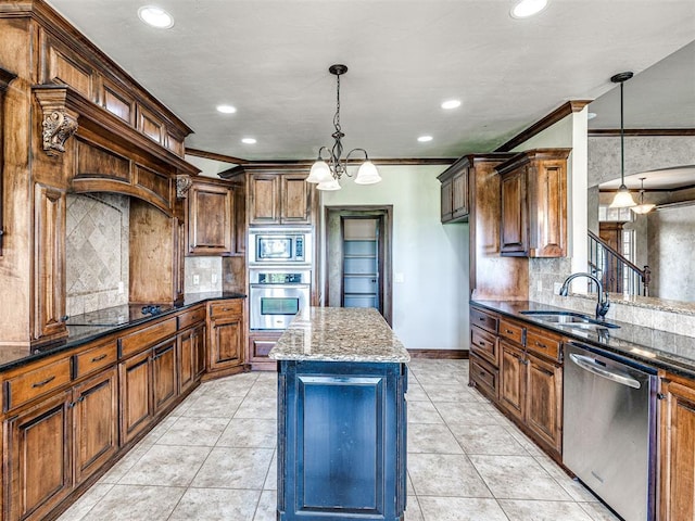 kitchen featuring hanging light fixtures, a kitchen island, sink, dark stone counters, and appliances with stainless steel finishes