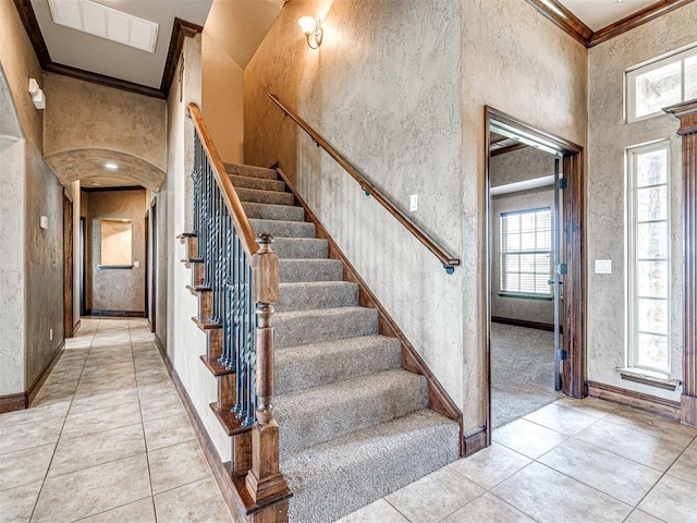 tiled foyer entrance featuring a high ceiling and crown molding