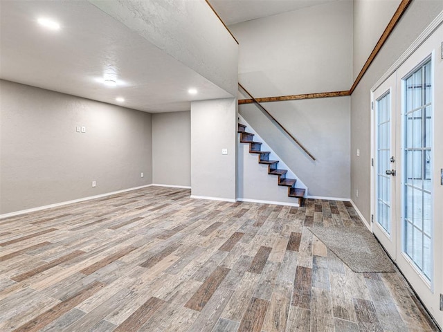 basement with light wood-type flooring and french doors